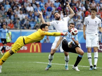 Frankreichs Torwart Hugo Lloris (l) faustet den Ball vor Uruguays Stürmer Stuani weg.