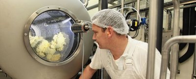 Butterproduktion bei der Vogtlandmilch. Mitarbeiter Toralf Hilbert kann die Herstellung durch ein Sichtfenster überwachen. Der Butterpreis ist nach Firmenangaben im März eingebrochen. 