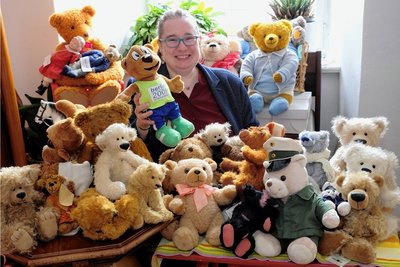 Museumsmitarbeiterin Grit Otto mitten in den Teddybären, die für die Weihnachtsausstellung im Neuberin-Museum bereits zusammengekommen sind. In der Hand hält sie ihren Berlino, das Maskottchen der Leichtathletik-Weltmeisterschaften von 2009 in Berlin.