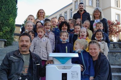 Handeln statt reden. Die Eltern von Erstklässler Cedric (vorn mit Mutter Nadine/links Vater Mike Döbereiner) haben der Weinhold-Grundschule einen Luftfilter geschenkt. Hinten links Schulleiterin Simone Wünsch, rechts Klassenlehrerin Sabine Böhm. Daneben Sebastian Müller von Hifi-Böhm, der sich um die neue Technik kümmert. 