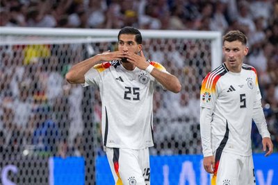 Can sendet Grüße auf die Tribüne.
