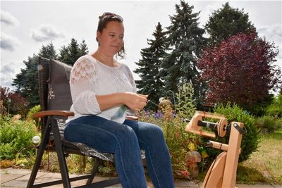 Nicole Hempel spinnt am Spinnrad Merino-Schafwolle.