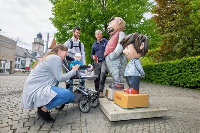 Holzbildhauer Hartmut Rademann (rechts) vorm Theatercafé im Gespräch mit Familie Matthes - Saskia, Benjamin und der einjährigen Tochter Pauline. Den "Sohn" hat der Handwerkskünstler hier komplett ersetzt.