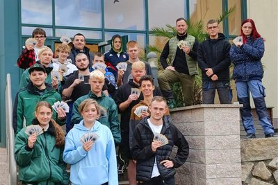 Die Schulklasse vom Berufsfeld „Agrarwirtschaft“, hier zusammen mit Ausbilder Sebastian Heinrich (oben Mitte) zeigt einige der Samentüten.