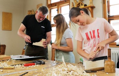Wie schnitzt man einen Fuß? Dieser schwierigen Aufgabe stellen sich in dieser Woche die jungen Schnitzer im Schloss Schwarzenberg. Im Bild: Holm Ludwig mit Larissa Marie Zimmermann und Kim Gündel. 