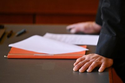 Akten auf einem Tisch in einem Gerichtssaal. Menschenhandel und Zwangsprostitution sind schwere Straftaten. An die Hintermänner zu gelangen, ist für Ermittler meist schwer.