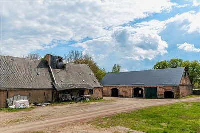 Links das ehemalige Mühlengebäude, welches abgerissen werden soll. Rechts die Scheune, deren Dach bereits saniert wurde. 
