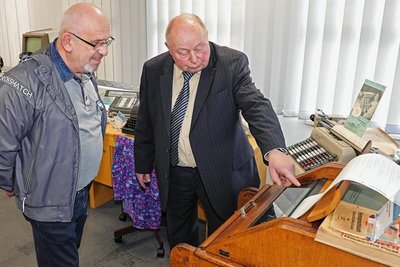 Auch Geräte und Technik aus verschiedenen Epochen vermitteln Sparkassen-Geschichte. Hier erklärt Horst Möckel in der Ausstellung Jörg Lanitz von der Umzugsfirma Gündel einen Fernschreiber aus DDR-Zeit. 