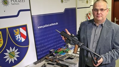 Ermittler Andreas Matthäi zeigt eine von dem 75-Jährigen selbst gebaute Maschinenpistole mit Ziel-Laser und Schulterstütze. 