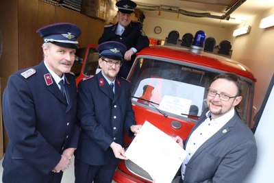 Bürgermeister Rolf Weigand (r.) übergibt den Fahrzeugbrief für den Barkas an Jens Kreisch (2.v.r.) vom Förderverein der Feuerwehr Hohentanne. Wehrleiter Torsten Ranft (l.) und sein Stellvertreter Lars Schulze schauen zu.
