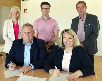 Monika Kube (Wohnungsbaugenossenschaft Erzgebirge), Sebastian Haustein (Gelenau Wohnungsgesellschaft) und Ausbau-Planer Matthias Bacher (h. v. l.) sowie Telekom-Regionalmanagerin Conny Wiegand und Gelenaus Bürgermeister Knut Schreiter unterzeichneten die Erklärung. 