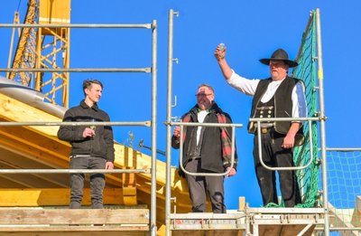 Nachdem Zimmermann Bernd Loos (rechts) den Richtspruch gesprochen hatte, schlugen Florian (links) und Heiko Dölz den letzten Nagel am neuen Dachstuhl ein. 