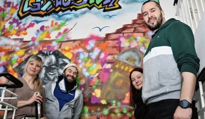 Nicole Wolf vom Förderverein der Schule "Am Zeisigwald", Künstler Georg Schatz, Nicole Eisfeld (Förderverein) sowie Erzieher Ronny Petzke (Foto von links) haben sich vor dem Graffiti-Werk platziert.