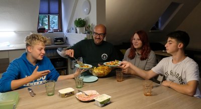 Joshua (l.), Emily und Josias mit Erzieher Christian Wiegand. Oft müssen die Jugendlichen ihre Mahlzeit aber auch selber kochen. 
