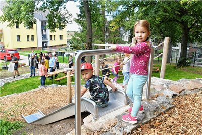 Endlich ist das Außengelände der Kindertagesstätte "Spatzenstübchen" in Augustusburg fertig. Am Freitagnachmittag waren die feierliche Eröffnung und das fröhliche Einspielen angesagt. Schaukel, Rutsche, Matschanlage und Co. gefallen den Kindern im Krippen- und Kindergartenalter. "Wir freuen uns, dass wir jetzt ein kindgerechtes Außengelände haben", sagte Leiterin Jana Werner. Das Spatzenstübchen an der Eppendorfer Straße war im Dezember 2020 eröffnet worden. Es ist eine Außenstelle der Kita "Spatzennest" an der Morgensternstraße. Träger ist das Deutsche Rote Kreuz. "Wir brauchten weitere Plätze, weil unser Haupthaus buchstäblich aus allen Nähten geplatzt ist", erzählt die Kita-Leiterin. 13 Kinder spielen und lernen seitdem im Spatzenstübchen. Bisher konnten sie ein eingezäuntes Grundstück vorläufig als Garten nutzen. Mobile Spielgeräte waren auch da. Aber jetzt kann es richtig losgehen mit dem Spielen und Rutschen. Alles ist fertig außer ein paar Pflanzarbeiten. Die neuen Außenanlagen haben rund 180.000 Euro gekostet. Etwa 72.000 davon kamen aus Fördertöpfen vom Landkreis Mittelsachsen und dem Freistaat Sachsen. eva