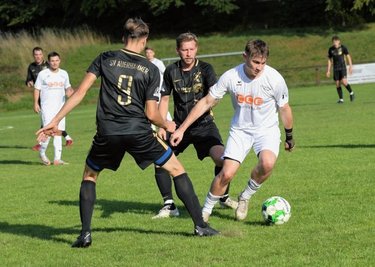 Der Zwickauer Nick Krämer (weißes Trikot) wird von zwei Auerhammer Spielern attackiert, lässt sich aber nicht vom Ball trennen. 