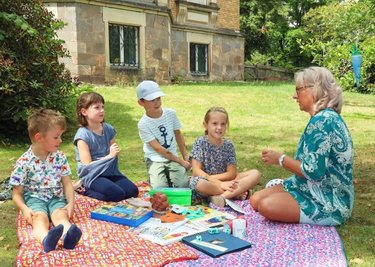 Sprach-Fachkraft Gabriele Bluhm mit Clara, Tim, Paula und Fidel in der "Philosophier-Runde" im Garten der "Sterntaler".