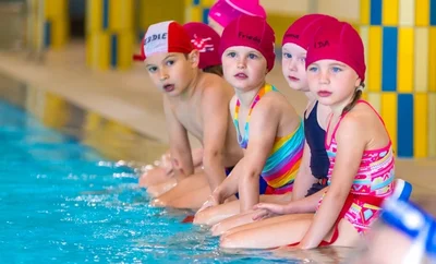 Die ausgebildeten Schwimmlehrer wissen sehr gut, wie sie die Minis am Beckenrand bei Laune halten. Im warmen Wasser sei es auch leichter als im Freibad, sagt Vereinschef Alexander Steiner. 