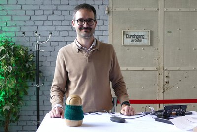 Christian Atz hat die Firma Bona Mondo gegründet. In solche Holzfiguren kommt das Handy mit dem Chatbot gegen Einsamkeit.