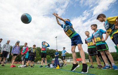Matteo Günther von der Astrid-Lindgren-Grundschule legt sich beim Medizinballschocken voll für sein Team ins Zeug.