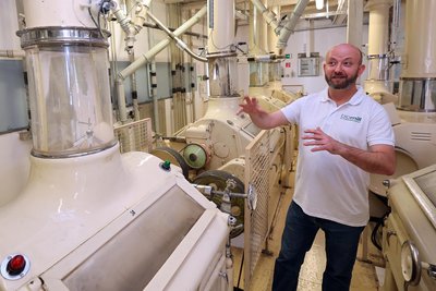 Betriebsleiter Jan Dörfler zwischen den gusseisernen Walzenstühlen der Mühle.