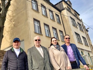Bürgermeister Siegfried Baumann sowie Harry Tröger, Isabel Passauer und Michael Tröger (von links) vor der ehemaligen Grundschule in Bockau, die zum Seniorenwohnpark umgebaut wird. 