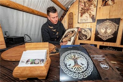 Kai Pan aus dem thüringischen Saalburg fertigt mit seiner Pyrographie genannten Brandmalerei Bilder auf Mittelaltermärkten an. Mittels eines Malgeräts, dessen Spitze elektrisch erhitzt und dabei bis 1000 Grad heiß wird, brennt er seine Motive in Holzplatten. 