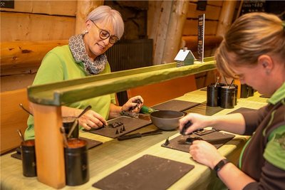 An 80 Plätzen können im Räucherkerzenland Crottendorf Räucherkerzen selbst gemacht werden. Mitarbeiter wie Constanze Geng (links) und Dana Kies leiten die Besucher an. Zurzeit ist die Einrichtung, die bald ein Jahr alt wird, zudem bei einem bundesweiten Wettbewerb am Start. Foto: Ronny Küttner/Photoron