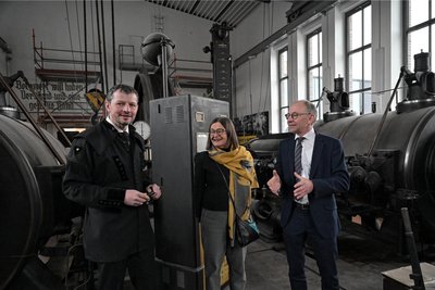 Museumsleiter Jan Färber (l.), Staatssekretärin Barbara Meyer und Beigeordneter Andreas Stark an der größten noch funktionsfähigen Dampfmaschine Sachsens. Der Raum ist fast fertig saniert.