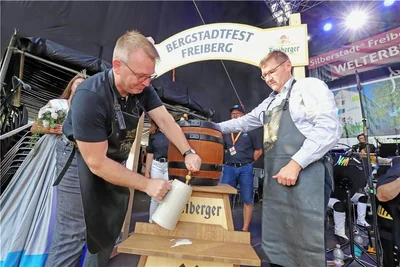 Oberbürgermeister Sven Krüger (l.) beim Fassbieranstich. Brauhaus-Geschäftsführer Holger Scheich assistiert.