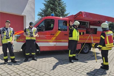 Einsatzleiter (gelbe Weste) und Führer der UAS-Einheit (rote Weste) vor einem Bildschirm, der das Livebild der Drohnenkamera darstellt. Daneben Pilot und Luftraumbeobachter, die für Flug und Sicherheit zuständig sind.