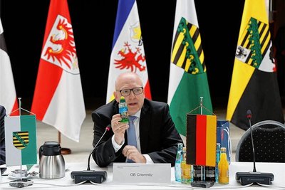 Der Chemnitzer Oberbürgermeister Sven Schulze stellt den Ministerpräsidenten zwei Chemnitzer Erfindungen vor, darunter die Fitflasche, die dem Roten Turm nachempfunden ist.