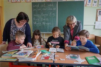 95 Millionen Euro gegen Lernlücken durch Corona: Wie schließen, wenn das Personal an den Schulen fehlt? - Maria Langenegger (li.) hilft Helge, Alina, Juna und Phil aus Bad Brambach beim Lesenlernen. Schulleiterin Annett Stahl ist froh, dass sie sie dafür gewinnen konnte.