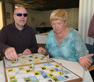 Reiner Groneberg und Gabriela Blechschmidt, die Schatzmeisterin im Verein Blinder und Sehbehinderter Aue-Schwarzenberg, am vorgestellten Brettspiel.