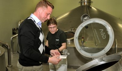 Geschäftsführer Marc Kusche im Sudhaus, wo Brauer Uwe Schumann gerade eine Probe von der Maische entnimmt.