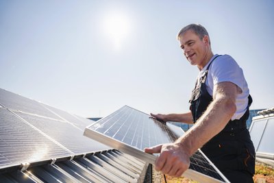 Ein Handwerker bei der Installation einer Solaranlage. Bei negativem Börsenstrompreis gibt es jetzt keine Einspeisevergütung mehr.