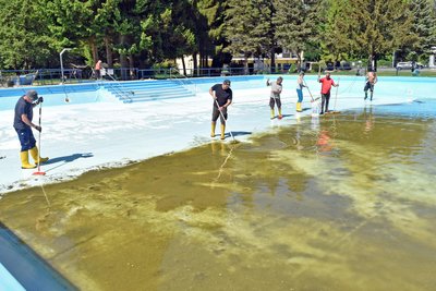 In Erdmannsdorf putzen Freiwillige Helfer das Nichtschwimmerbecken.