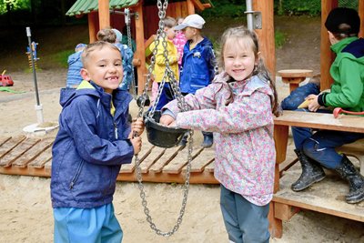 John (links) und Marie spielen ausgelassen im Außengelände der Kita „Gockelhahn“.