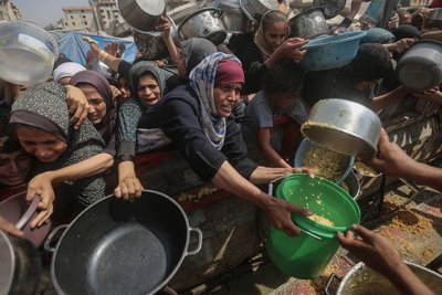 Palästinensische Frauen und Kinder drängen sich in Gaza-Stadt an einer Ausgabestelle, um etwas Essen zu bekommen.