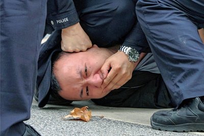 Polizisten halten in Shanghai einen Demonstranten fest, der gegen die Coronapolitik protestiert hatte.