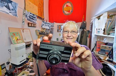 Mit der Kunststoff-Kamera «beirette» in der Hand steht die ehemalige Krankenschwester Heidi Dentler inmitten ihres «Honniland» in Chemnitz.