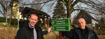 Daniel Zimmermann (l.) und Ortsvorsteher Bernd Emmrich an den neuen Wegweisern an der Kirche in Marbach. Auch die Wanderwege des Ortes sollen noch beschildert werden. 