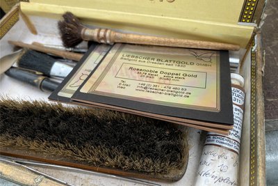 Die Zigarrenkiste als Werkzeugkasten. Zum Handwerkszeug des Schrifthauers gehören auch Bürsten zum Säubern von Oberflächen und Pinsel zum Auftupfen des Blattgolds.