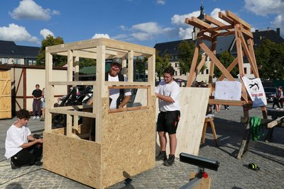 Mit seinen Lehrlingen Silas Seiler (links) und Valentin Jahn baute Conrad Scheffler (Mitte) auf dem Holzmarkt einen Hochstand.