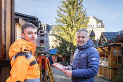 Vermessen am Mittwochvormittag den Baum auf dem Weihnachtsmarkt in Annaberg: Julian Rielemann (l.) und Alexander Neumeister.