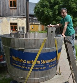 Mit einem Bottich unterwegs: Mit einem mobilen Holzbadezuber tourt Danilo Braun (37) aus Langhennersdorf durch die Lande. In dem Badefass können seinen Angaben zufolge "bis zu acht Personen zugleich entspannen". Die Nachfrage sei gut, so bei Junggesellenabschieden oder Familienfeiern. Kostenpunkt: rund 150 Euro pro Wochenende. Zudem betreibt Braun gemeinsam mit Tino Schubert eine mobile Kelterei. Anmeldung unter 01577 3987764. (hh)  