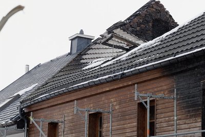 Die Hitze der Flammen hat das Blechdach des Mehrfamilienhauses in der Langen Gasse deformiert. Ein Löschangriff von innen war für die Einsatzkräfte der Feuerwehr nicht möglich. Sie mussten von außen löschen und dafür Schindeln abreißen.