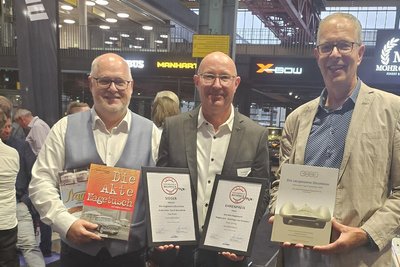 „Motorworld Buchpreis“-Verleihung in München. Verleger und Autor Christian Suhr (Mitte) mit Herausgeber Frank Hartwig (links) und Autor Jörg Geisler.