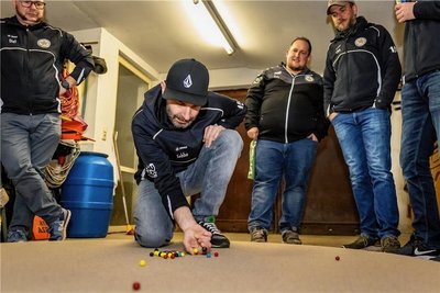 Sebastian Mehnert versucht, mit dem "Tolley" genannten Spielball, andere Murmeln vom Spielfeld zu schießen. 