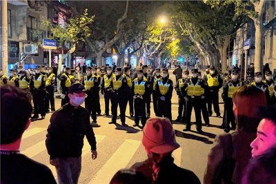 Chinesische Polizisten versperren den Zugang zu einem Platz, an dem sich Demonstranten versammelt hatten. In China hat die strenge Coronapolitik zu den größten Protesten seit Jahrzehnten geführt.